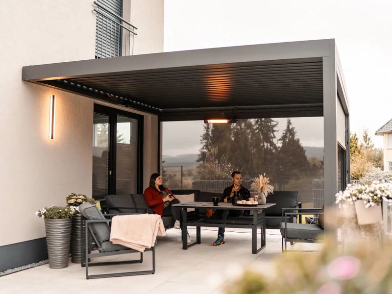 PERGOLUX Pergola 4 an der Hauswand über einer Sitzgruppe